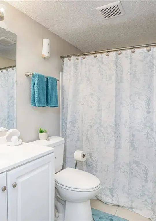 a bathroom with a shower curtain, toilet and sink at The  Element At 464