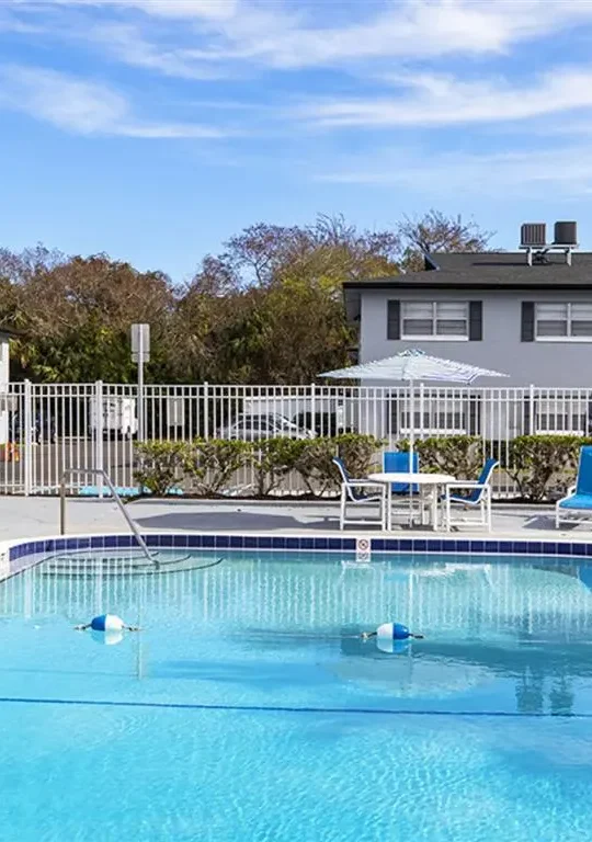 a pool with chairs and a fence around it at The  Element At 464