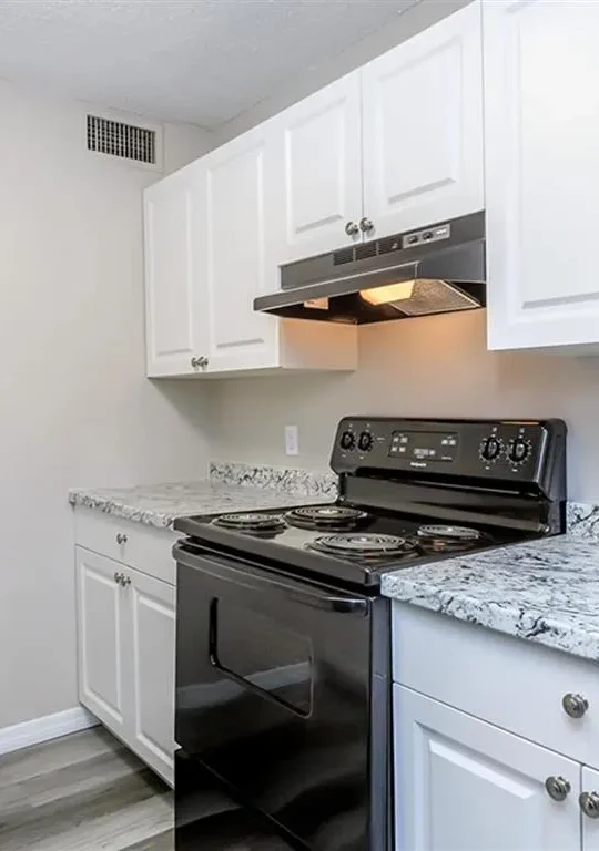 kitchen with white cabinets and black stove at The  Element At 464